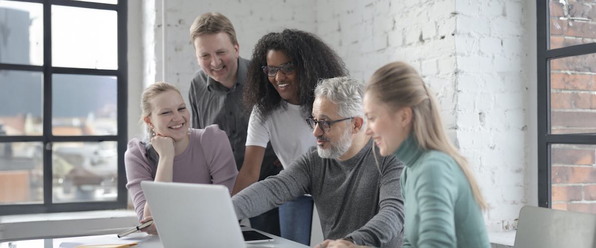 Smiling group of colleagues discussing project in office