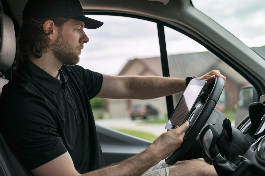Man stops over and checks his work order for next job and route